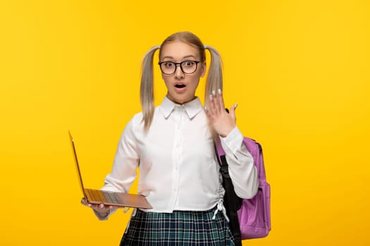 world book day surprised blonde student with waving hands holding a computer