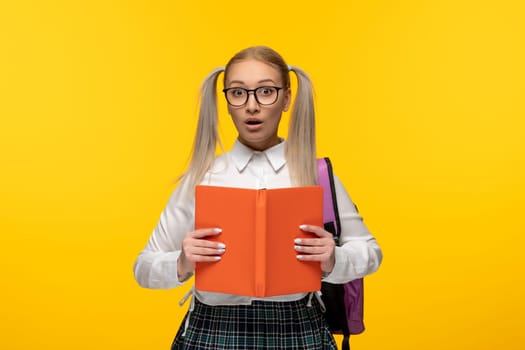 world book day surprised blonde young student holding an open book