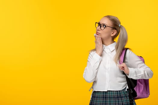 world book day thinking blonde girl with ponytails and pink backback on yellow background