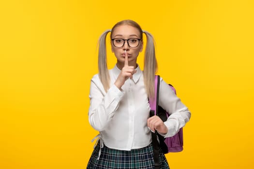 world book day young blonde girl in white shirt showing silence gesture