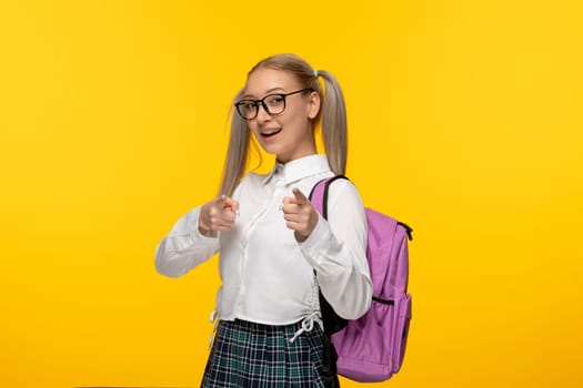 world book day young blonde schoolgirl with ponytails and pink backback showing good hand gesture