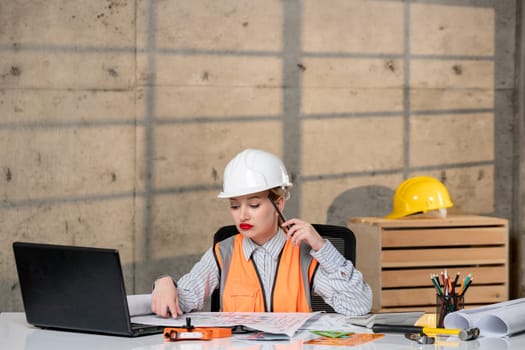 engineer smart young cute blonde girl civil worker in helmet and vest thinking of building