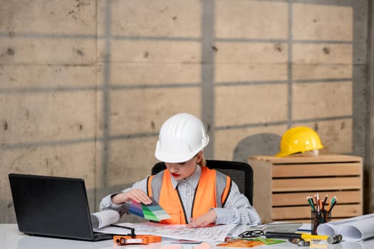 engineer smart young cute blonde girl civil worker in helmet and vest with ruler