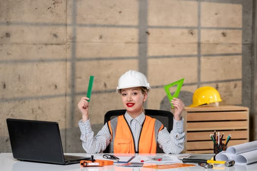engineer smart young cute blonde girl civil worker in helmet and vest working on house
