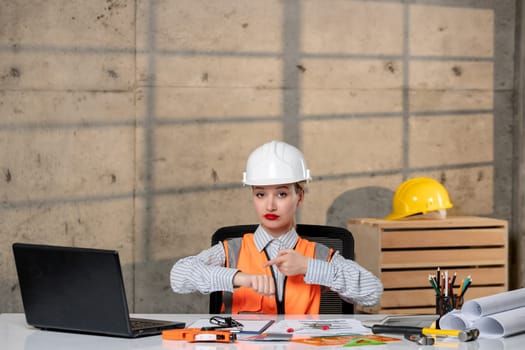 engineer young smart cute blonde girl civil worker in helmet and vest late