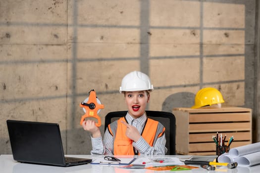 engineer young smart cute blonde girl civil worker in helmet and vest with tools