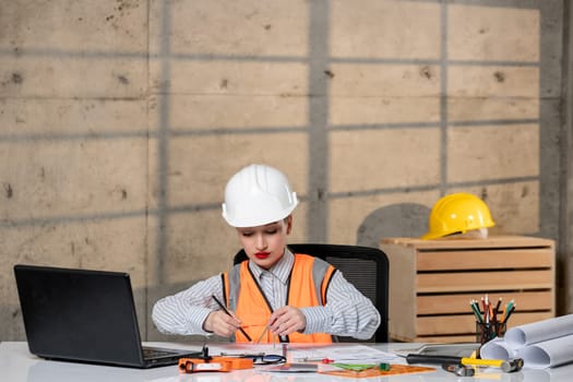 engineer civil worker in helmet and vest smart young cute blonde girl drawing project