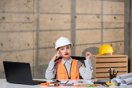 engineer civil worker in helmet and vest smart young cute blonde girl thinking