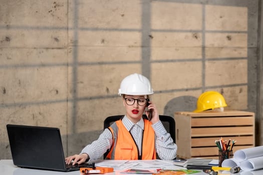 engineer in helmet and vest civil worker smart young cute blonde girl on phone call