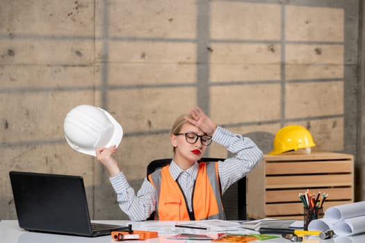 engineer in helmet and vest civil worker smart young cute blonde girl tired