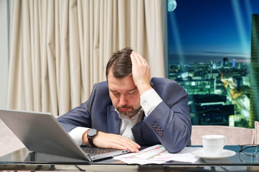 Tired man working at home office, Exhausted, stressed, overworked man, financial market decline, unsuccessful investments. tension headache. Sad businessman lying on laptop.