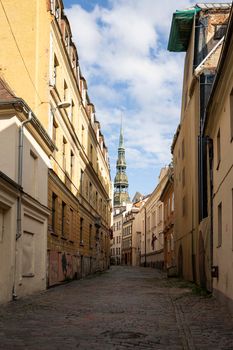 Riga, Latvia. 22 August 2021.  an old street in the city center with the bell tower of the church of St. John's Church in the background