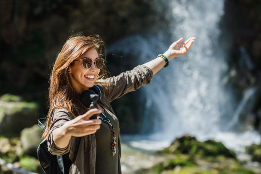 Shot of a smiling young woman enjoying day in nature.