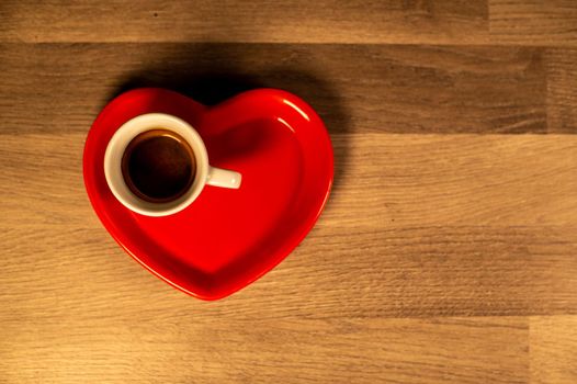 valentine heart saucer with coffee cup on wooden table