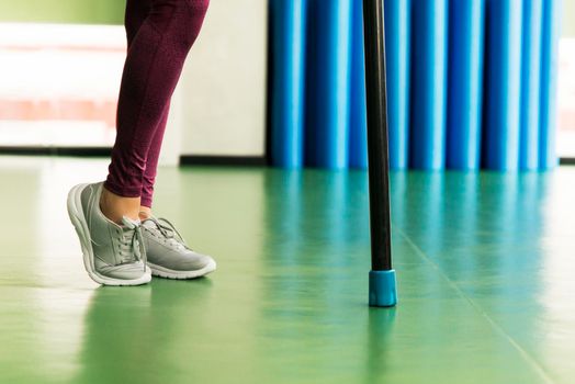 Legs of Young fit woman doing exercise with bodybar in a gym