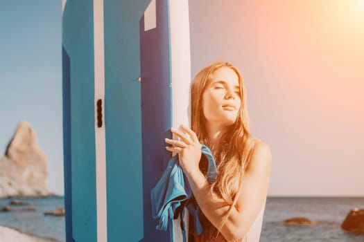 Close up shot of happy young caucasian woman looking at camera and smiling. Cute woman portrait in bikini posing on a volcanic rock high above the sea