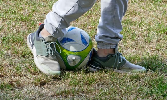 The legs of a boy who makes soccer exercises