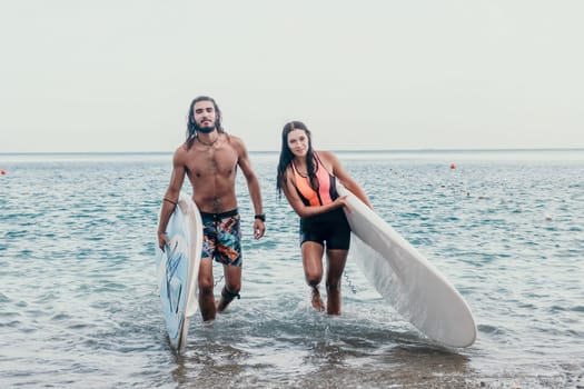 Sea woman and man on sup. Silhouette of happy young woman and man, surfing on SUP board, confident paddling through water surface. Idyllic sunset. Active lifestyle at sea or river