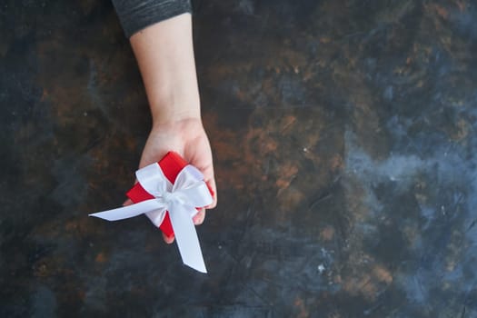 Woman holding small red present box in hands. High-quality photo