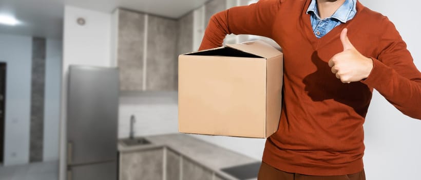 enthusiastic young man carrying cardboard box, moving out of home.