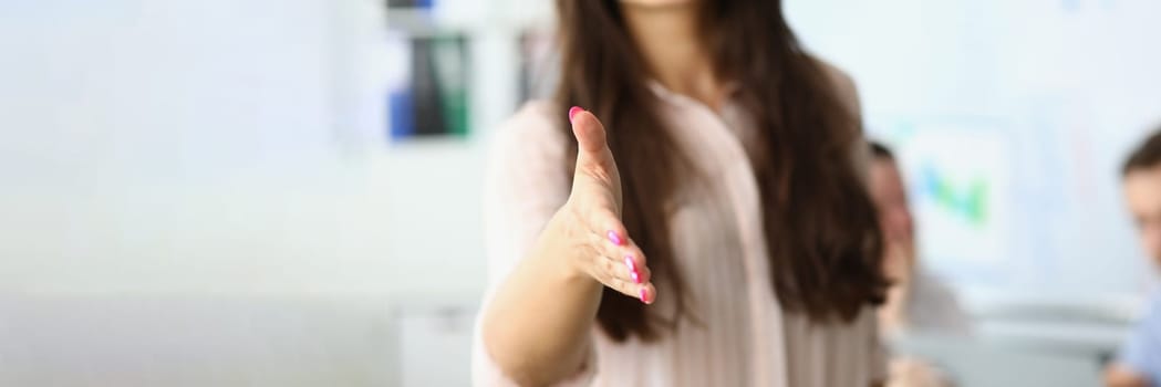 Closeup of business woman holding out hands for handshake and welcome gesture. Business meeting in office and handshake concept