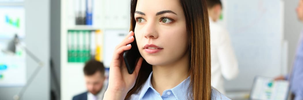 Portrait of beautiful businesswoman with phone in office. Business consultant and stay connected concept