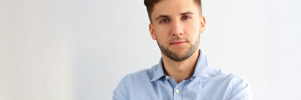 Portrait of handsome young business man posing for camera. Smart attractive guy employee consultant manager in blue shirt