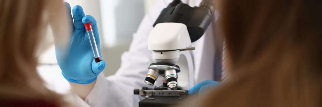 Scientists in the laboratory examine blood sample in sample tube. Dna analysis concept