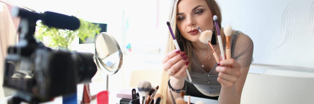 Beauty blogger shoots daily women makeup routine videos on camera. Selection of brushes for applying makeup concept