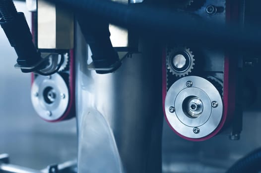 A pair of pulleys with toothed belts as part of a production facility. Timing chain of a car, tensioners in the engine. Industrial roller chain, technology. Teamwork, business concept.