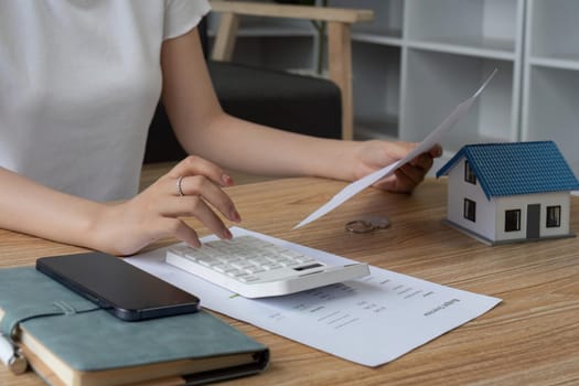 Close up of woman busy calculating household finances or taxes on machine, female manage home family expenditures, using calculator.