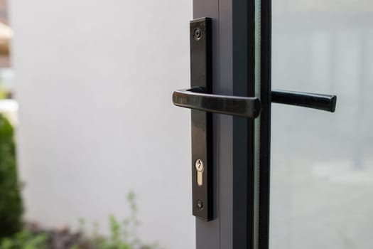 Door handle with lock on a glass door with access to the backyard.