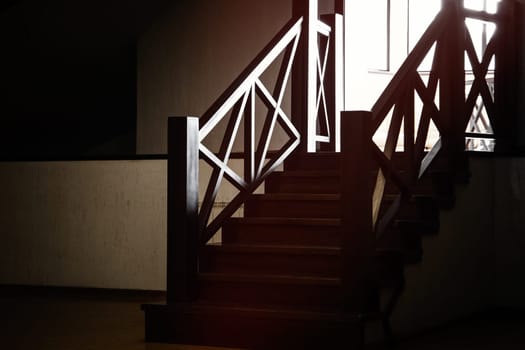 A small wooden staircase in a dark attic room of a mansion.