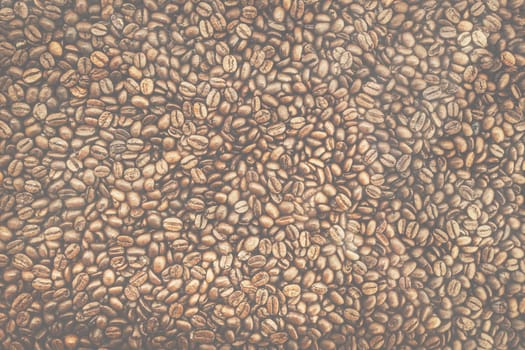 Background of brown roasted coffee beans, top view matte texture.