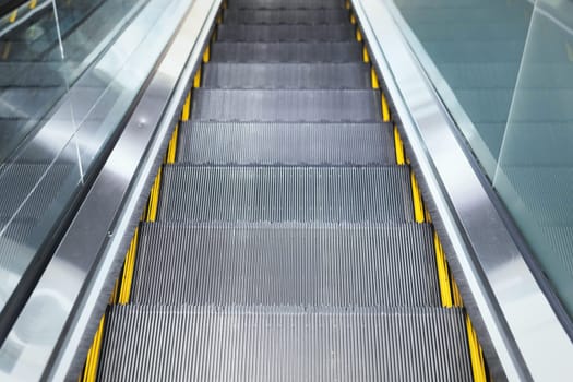 Top view on steps of escalator modern buildings or subway station.