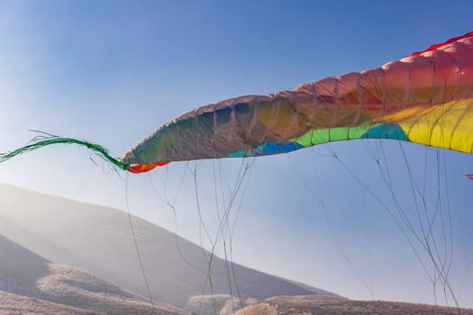 Part of a colorful parachute wing when landing in a hilly area.