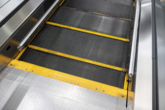 Close-up of the beginning of the escalator. Yellow restrictive notches on the escalator.