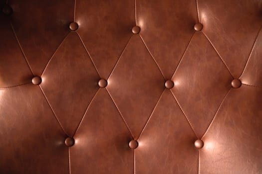 Brown leather texture with buttons for pattern or background.