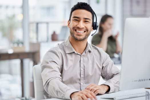 Customer service, portrait of male call center agent with headset and with computer at his desk of a modern office workplace. Telemarking or support, communication and male person at his workstation.