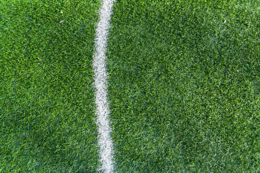 Top view white stripe markings on the green lawn of the sports field.