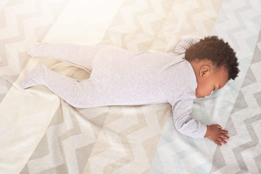 Top view, bedroom and baby sleeping in home for rest, nap time and dreaming in nursery blanket. Childcare, newborn and above of cute, tired and African child in bed sleep for comfort, relax and calm.