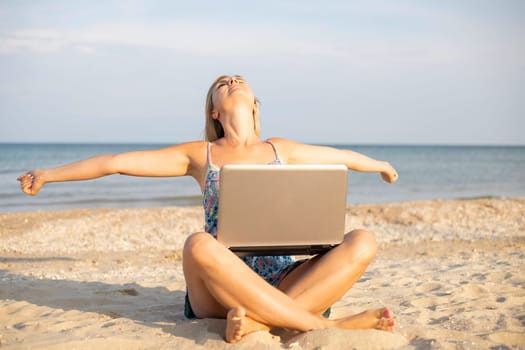 Beautiful young woman working with laptop on the tropical beach. Successful person concept.