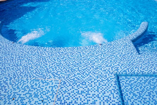 Empty Swimming pool with waterfall jet and jacuzzi in action