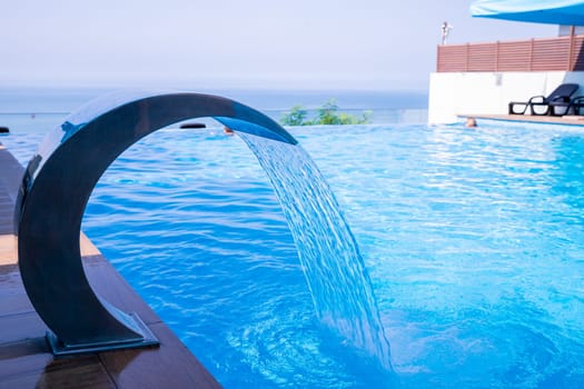 Empty Swimming pool with waterfall jet and jacuzzi in action