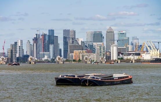 Woolwich, London - 15 May 2023: Skyline of city district of London and Thames Barrier from Woolwich