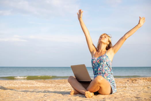 Beautiful young woman working with laptop on the tropical beach. Successful person concept.