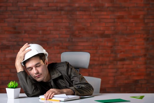 front view male engineer sitting behind his working place and falling asleep document plan job corporate contractor agenda property builder