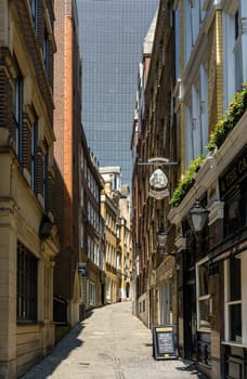 London, UK - 14 May 2023: Narrow street of Lovat Lane in City of London with skyline dominated by skyscraper