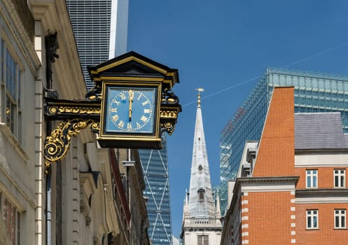 Old traditional city buildings with antique clock on St Mary at Hill street in London