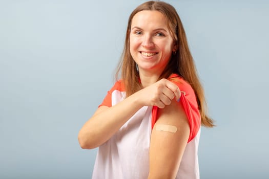 Vaccination COVID-19. Vaccinated woman showing hand with plaster cast after injection of coronavirus vaccine. Successful Covid-19 vaccination.